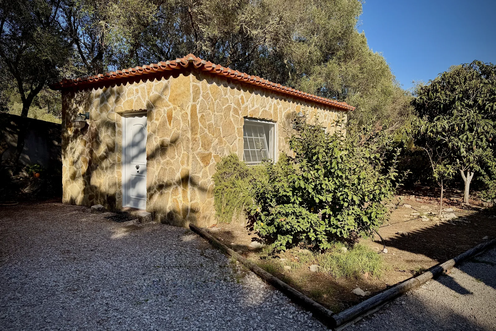 A casinha de pedra onde decorrem as aulas de yoga, na Quinta do Pé Descalço em Sintra, rodeada de oliveiras.