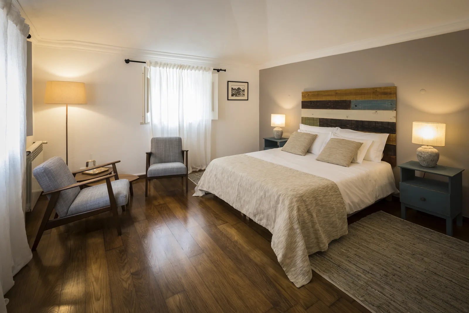 Quarto Regaleira da Quinta do Pé Descalço em Sintra, com cama de casal e cabeceira em madeira recuperada, para quem fica alojado.