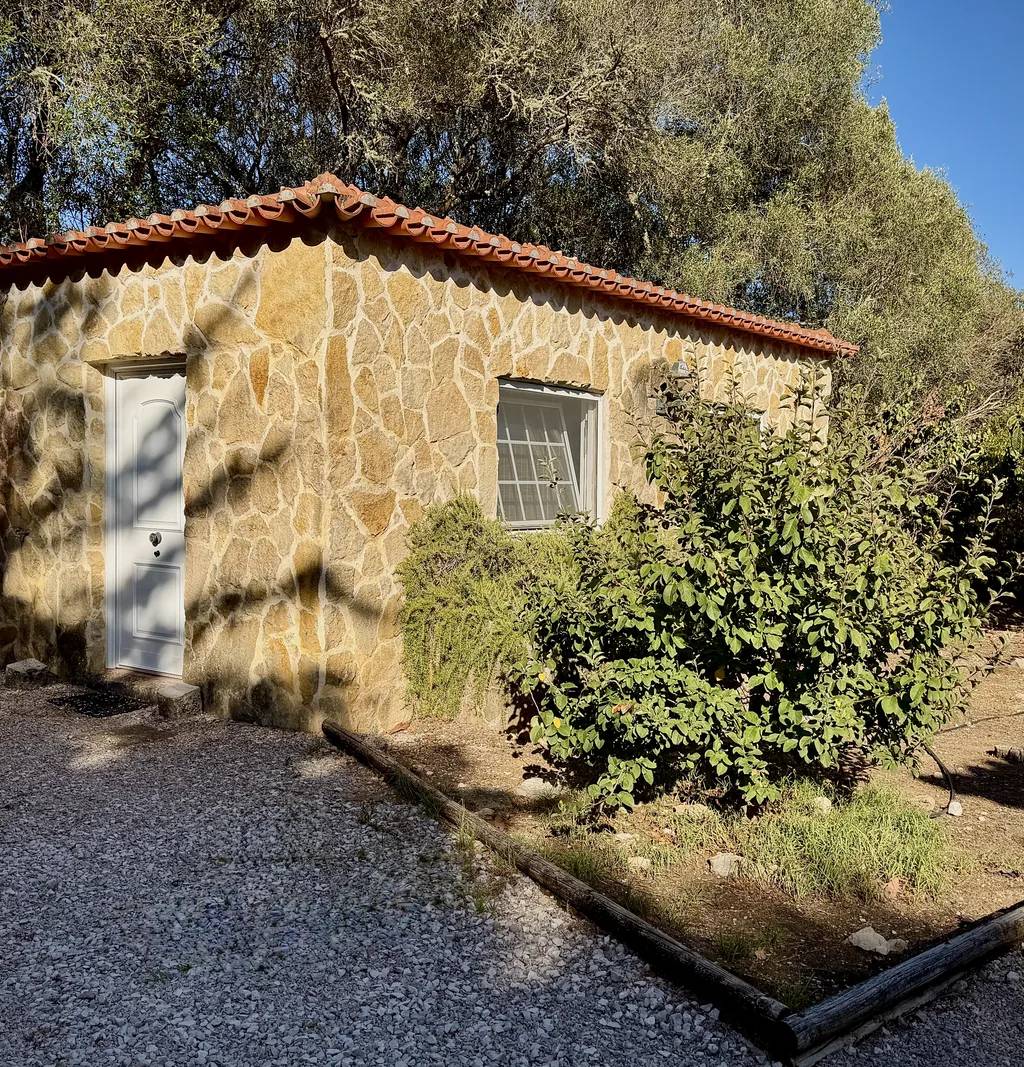 A casinha de pedra onde decorrem as aulas de yoga, na Quinta do Pé Descalço em Sintra, rodeada de oliveiras.